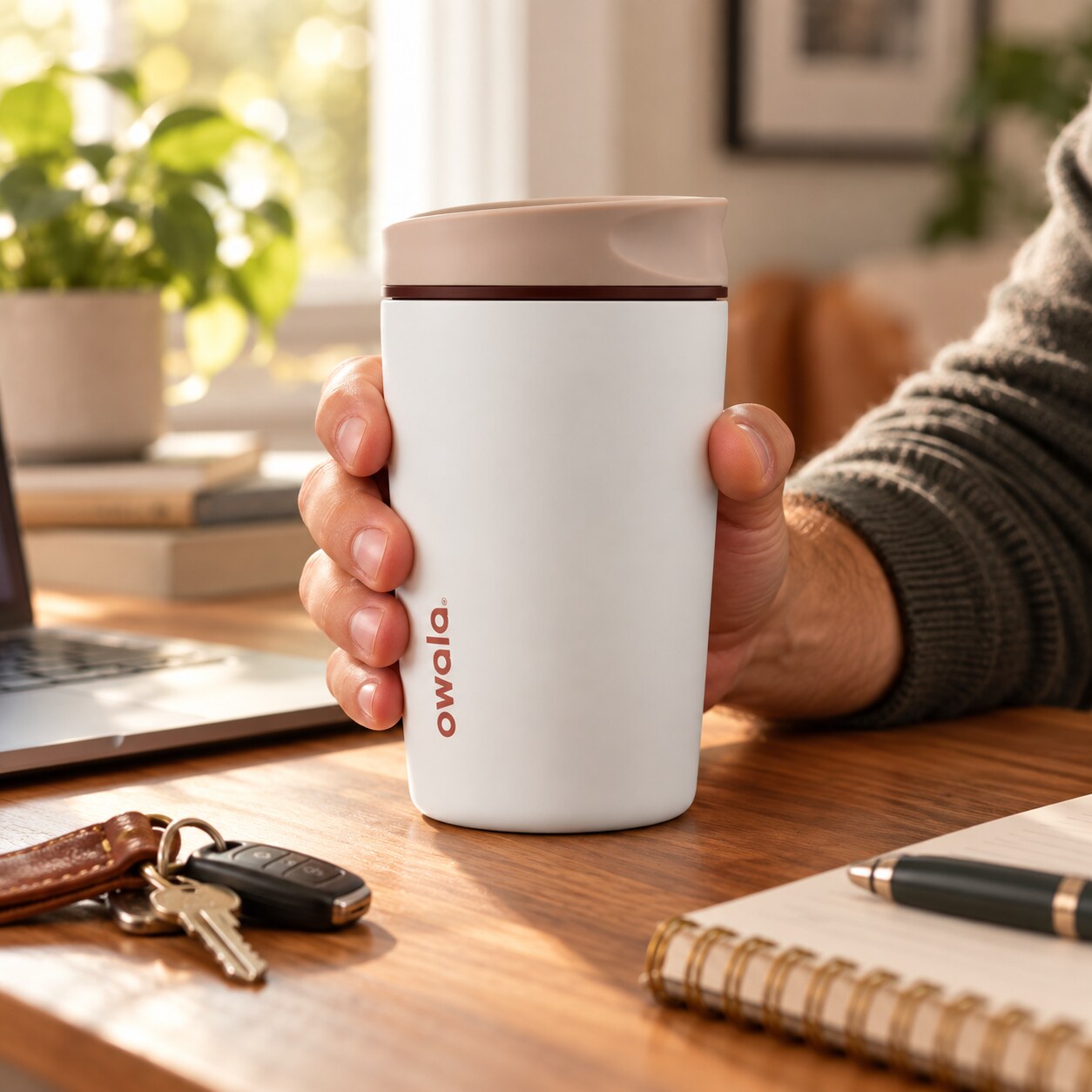 White Owala travel mug held during a morning routine