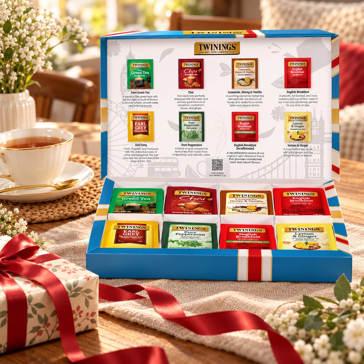 Twinings tea assortment gift set beside a cup of tea and wrapped present